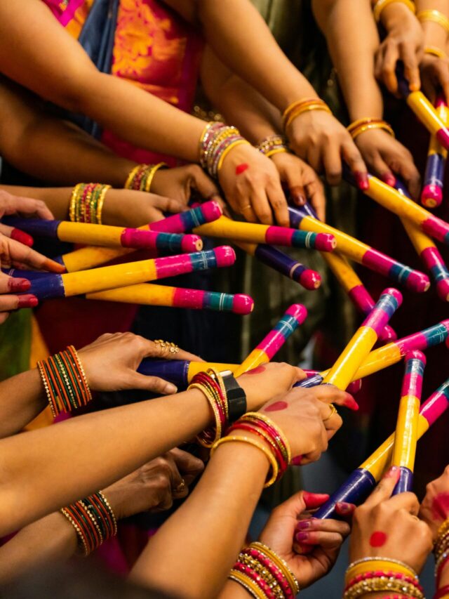 Colorful display of hands with dandiya sticks celebrating Navratri festival, showcasing Indian culture.