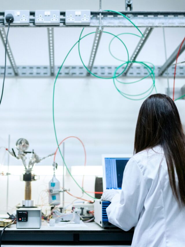 A female scientist conducting research in a contemporary laboratory full of equipment.