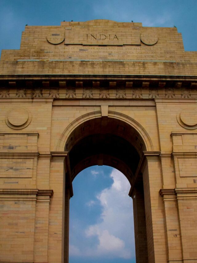 Majestic view of India Gate under a vibrant blue sky in New Delhi, India.