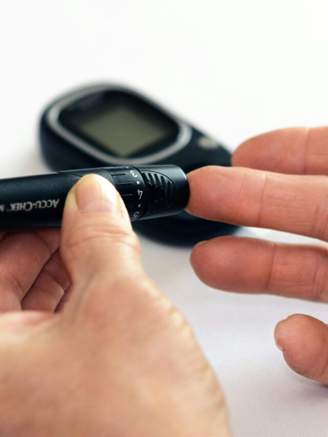 Close-up image of a person using a glucometer for diabetes management indoors.