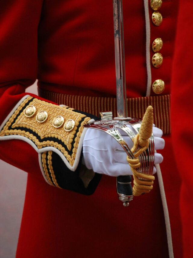 Close-up of a British guard in traditional uniform holding a ceremonial sword.